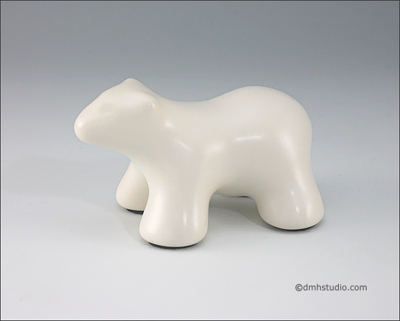 Large image of baby polar bear sculpture in carrara white, profile facing left.