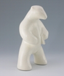 Standing polar bear sculpture with book, in carrara white glaze. Portrait facing to the viewers right.