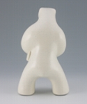 Standing polar bear sculpture with book, in carrara white glaze. Back view facing away from the viewer.