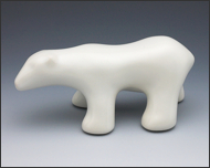 Image of walking polar bear sculpture in carrara white, profile facing the viewers left.