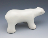 Image of walking polar bear sculpture in carrara white, profile facing the viewers right.