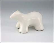 Image of baby polar bear sculpture in carrara white, profile facing left.
