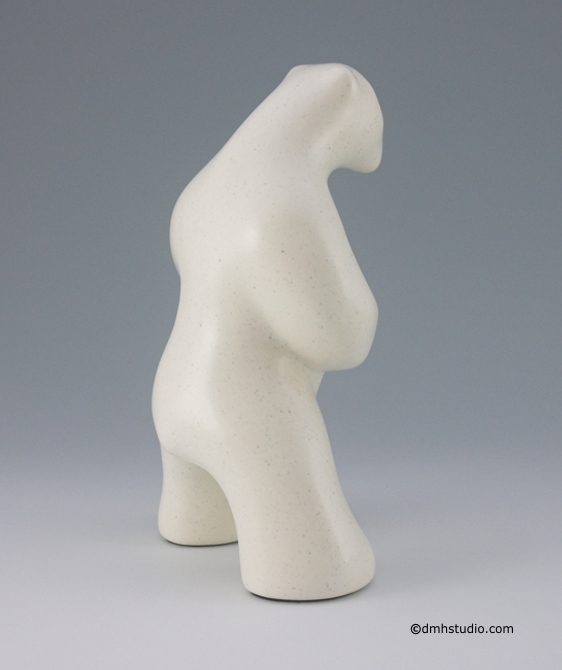 Large image of standing polar bear sculpture with book, in carrara white glaze. Profile facing away and to the viewers right.