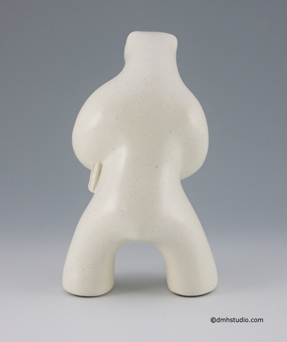Large image of standing polar bear sculpture with book, in carrara white glaze. Back view facing away from the viewer.