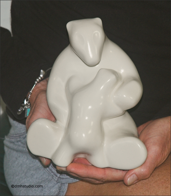 Large image of mother and child polar bear sculpture in carrara white, portrait facing out to the viewer, being held by Mary K.