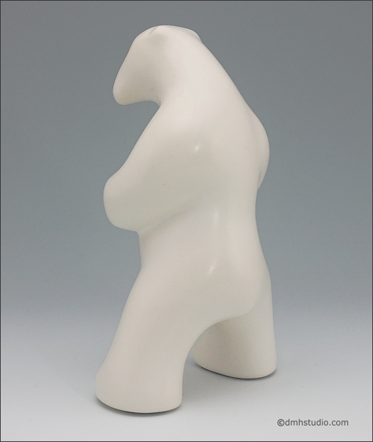 Large image of standing white polar bear sculpture, portrait facing away and slightly to the viewers left.