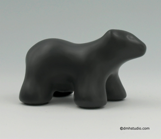 Large image of baby polar bear sculpture in diamond black. Portrait facing the viewers right.