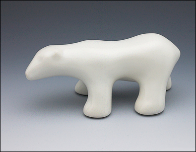 Image of walking polar bear sculpture in carrara white, profile facing the viewers left.