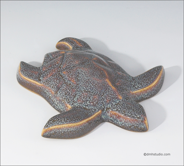 Large image of Baby Sea Turtle sculpture in starfield blue glaze, seen  from above, facing to the viewers lower right.