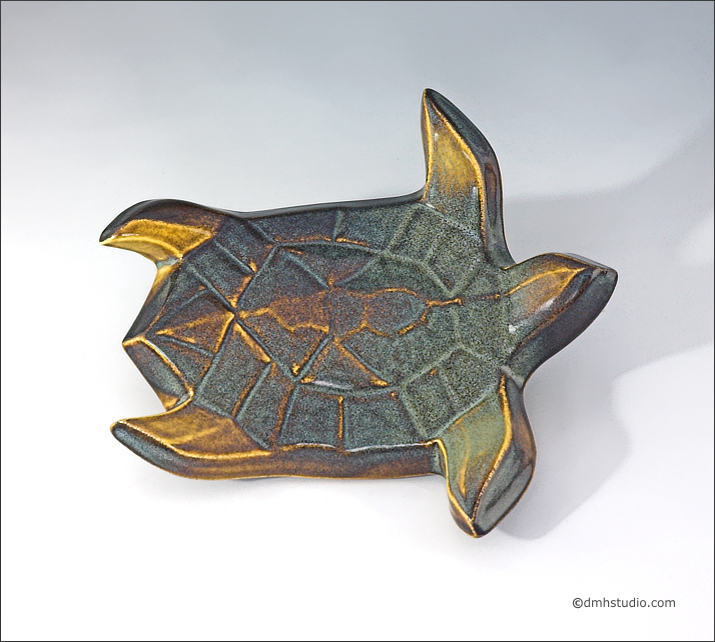 Large image of Flying Sea Turtle sculpture in gold and green glaze, seen  from above, facing the viewers right.